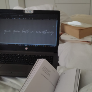 Livre 'lait et miel' de Rupi Kaur et ordinateur avec la citation : "give your best in everything".